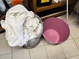 a bucket and a pink bucket sitting on the floor