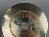 pair of silver plate with a man ' s face in the center