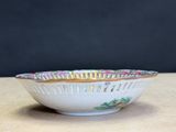 a white bowl with colorful designs on it sitting on a table