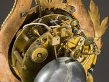a close up of a clock with a pendulum on it
