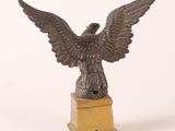 statue en bronze représentant un oiseau sur un socle, sur fond blanc