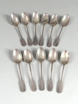six silver spoons are arranged in a row on a white surface