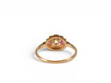 a close up of a gold ring with a pink stone