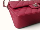 a pink purse that is sitting on a white surface