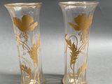 two vases with gold designs on them on a table