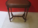 a small table with a brown leather top on a white floor