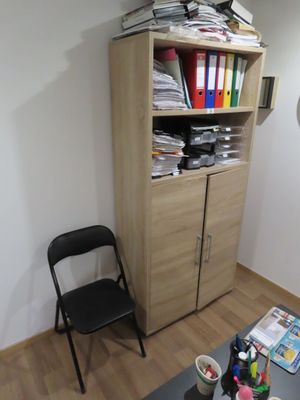 une table, une chaise et une bibliothèque dans un coin