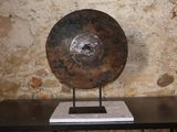 un grand objet métallique posé sur une table devant un mur de pierre