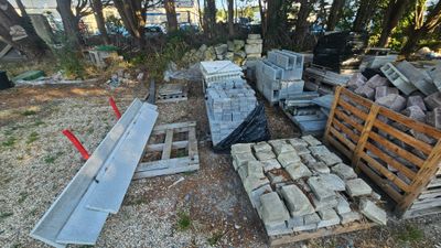 un tas de briques posé par terre à côté d'un tas de palettes