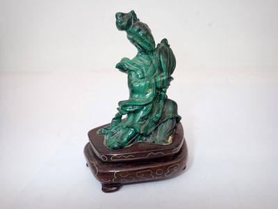 une petite statue représentant un dragon, posée sur un socle en bois