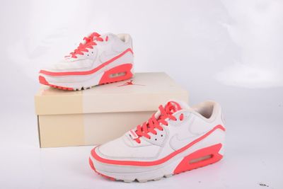 des baskets Nike Air Max blanches et roses dans une boîte, sur fond blanc