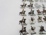 many figurines of people riding horses in a row