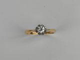 a single stone diamond ring on a white surface