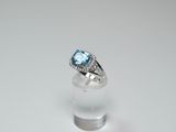 a close up of a ring with a blue topaz stone in it