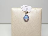 Un pendentif en oplite et diamant est suspendu à un écrin blanc