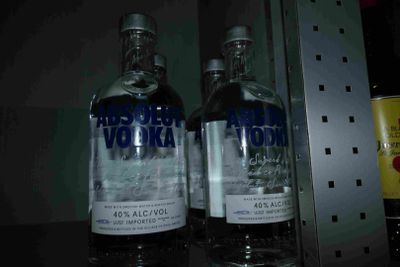 two bottles of vodka on a shelf next to each other
