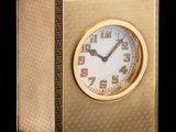 une horloge dorée posée sur une surface noire