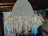 a large straw hat hanging from the ceiling in a living room
