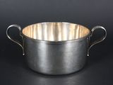a large metal pot with two handles on a black background