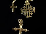 three gold crosses and a cross pendant on a black background