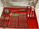 un coffret rouge contenant de l'argenterie sur une table