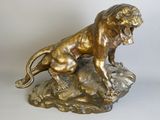bronze statue of a lion on a rock on a white background