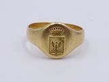 a close up of a gold ring with a crest on it