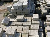 a pile of bricks sitting on the ground next to a fence