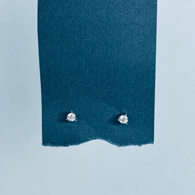 un gros plan sur une paire de boucles d'oreilles posées sur un morceau de tissu bleu