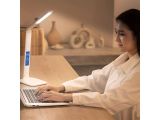 a woman that is sitting at a desk with a laptop