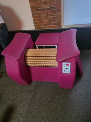 a pink chair that has a bunch of cookies on it