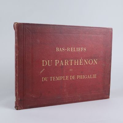 un vieux livre rouge orné de lettres dorées, posé sur une surface blanche