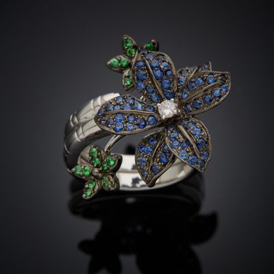 a close up of a ring with blue and green stones on it