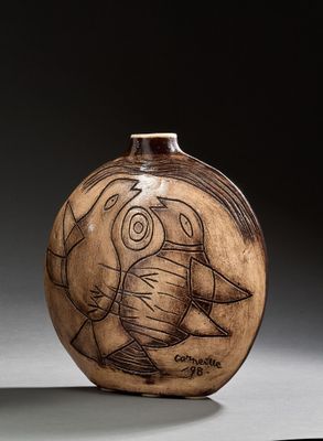 un vase marron orné d'un dessin, posé sur une table