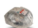 un morceau de pain emballé dans du plastique posé sur une surface blanche