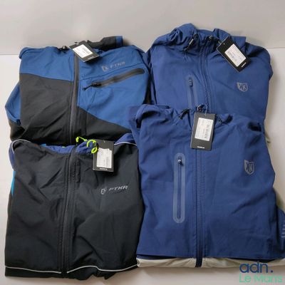 three pairs of blue and black jackets sitting on top of a table