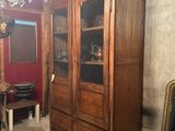a large wooden cabinet with a glass door in a room