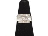 un gros plan d'une bague en diamant posée sur un présentoir noir