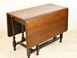 an antique oak drop leaf table with turned legs and a drop leaf top