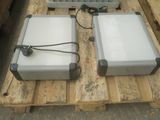 two suitcases sitting on a pallet with wires attached to them
