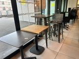 des tables et des tabourets devant une grande baie vitrée dans un restaurant