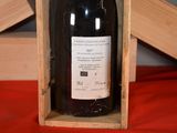 a bottle of wine in a wooden box on a red cloth