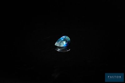 une pierre bleue dans l'obscurité, sur fond noir