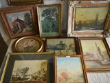 a lot of paintings on a table with a white table cloth