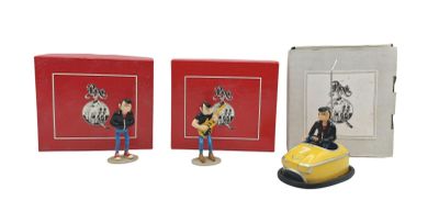 two figurines of a man and a woman sitting on a car