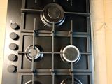a black stove top with pots and pans on it