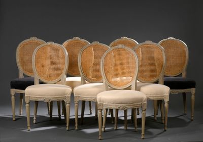 six chaises avec des coussins de dossier en rotin et un coussin noir