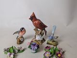 several figurines of birds and flowers on a white surface