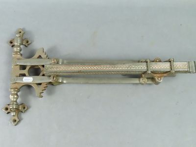 une épée ancienne plaquée argent posée sur une surface blanche
