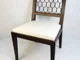 the back of a wooden chair with a white cushion on it
